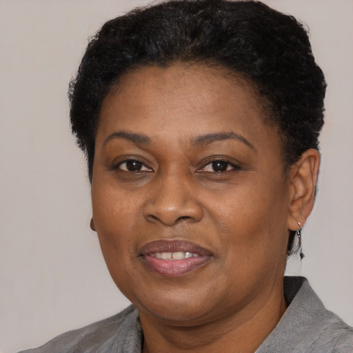 Joyful black adult female with short  black hair and brown eyes