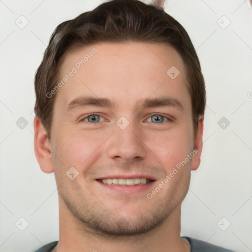 Joyful white young-adult male with short  brown hair and grey eyes