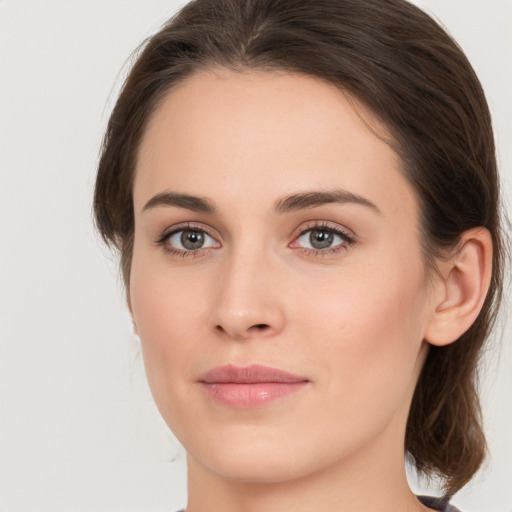 Joyful white young-adult female with medium  brown hair and grey eyes