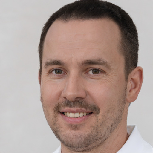 Joyful white adult male with short  brown hair and brown eyes