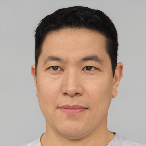 Joyful asian adult male with short  brown hair and brown eyes