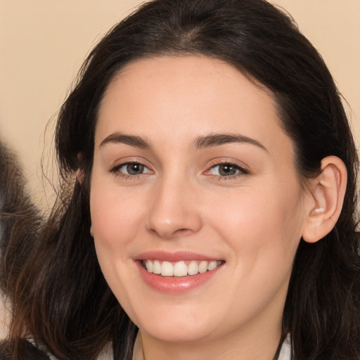 Joyful white young-adult female with long  brown hair and brown eyes