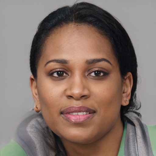 Joyful black young-adult female with long  black hair and brown eyes