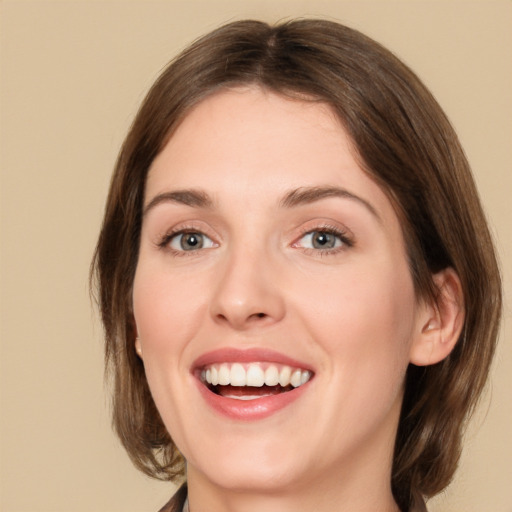 Joyful white young-adult female with medium  brown hair and green eyes