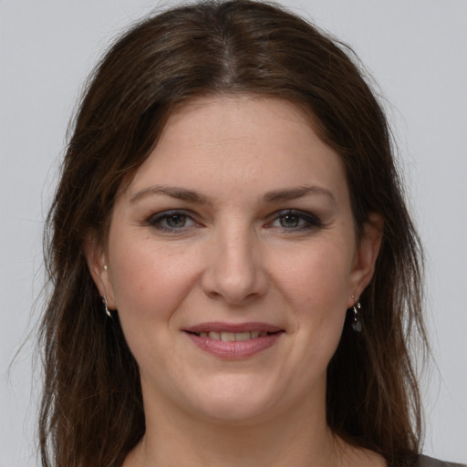 Joyful white young-adult female with long  brown hair and grey eyes