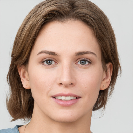 Joyful white young-adult female with medium  brown hair and green eyes