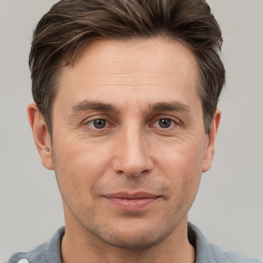 Joyful white adult male with short  brown hair and grey eyes