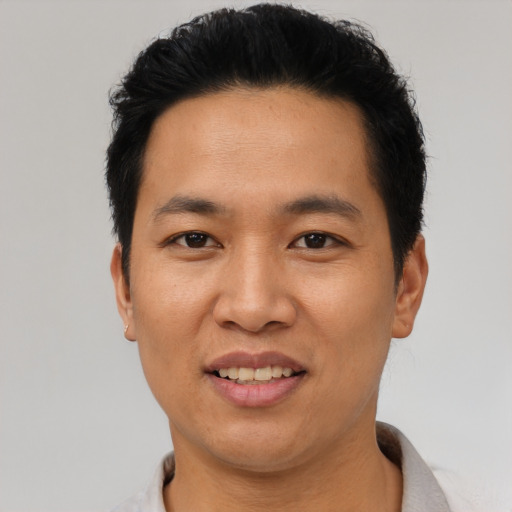 Joyful asian adult male with short  black hair and brown eyes