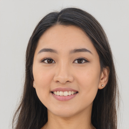Joyful asian young-adult female with long  brown hair and brown eyes