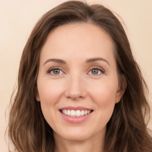 Joyful white young-adult female with long  brown hair and grey eyes