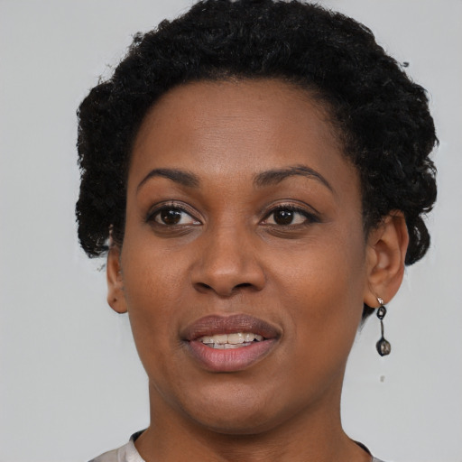 Joyful black young-adult female with short  brown hair and brown eyes