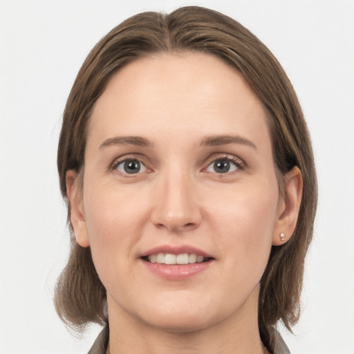 Joyful white young-adult female with medium  brown hair and grey eyes