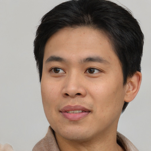 Joyful asian young-adult male with short  brown hair and brown eyes