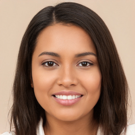 Joyful latino young-adult female with long  brown hair and brown eyes