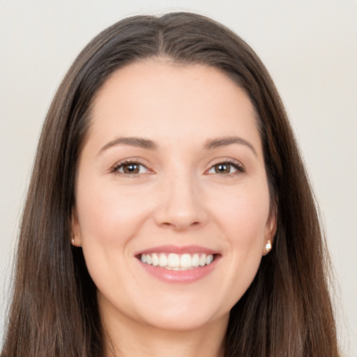 Joyful white young-adult female with long  brown hair and brown eyes