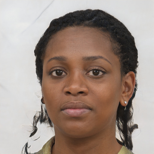 Joyful black young-adult female with long  black hair and brown eyes
