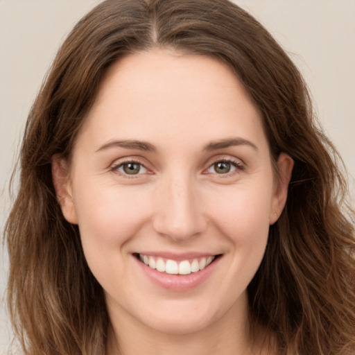 Joyful white young-adult female with long  brown hair and brown eyes