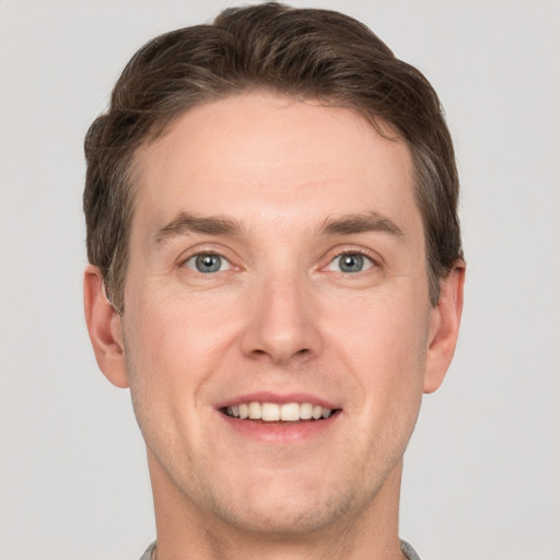 Joyful white adult male with short  brown hair and grey eyes