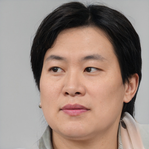 Joyful asian young-adult male with medium  brown hair and brown eyes