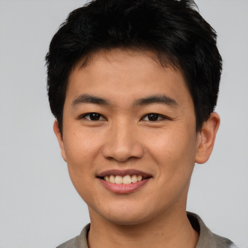 Joyful asian young-adult male with short  black hair and brown eyes