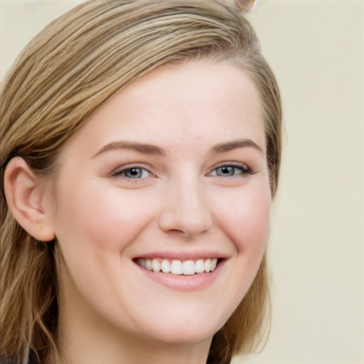 Joyful white young-adult female with long  brown hair and blue eyes