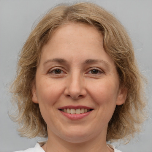 Joyful white adult female with medium  brown hair and brown eyes