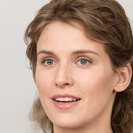 Joyful white young-adult female with medium  brown hair and green eyes