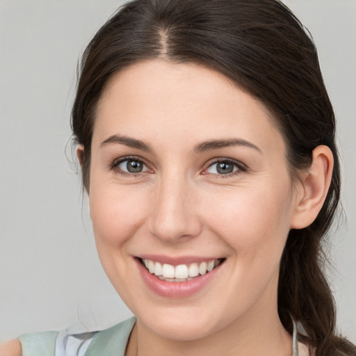 Joyful white young-adult female with medium  brown hair and grey eyes