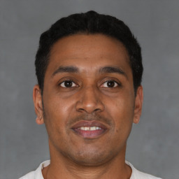 Joyful latino young-adult male with short  black hair and brown eyes