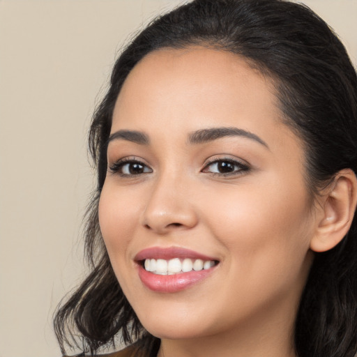 Joyful white young-adult female with long  black hair and brown eyes