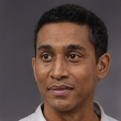 Joyful black adult male with short  black hair and brown eyes