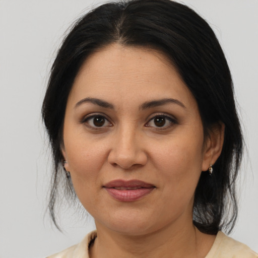Joyful latino adult female with medium  brown hair and brown eyes