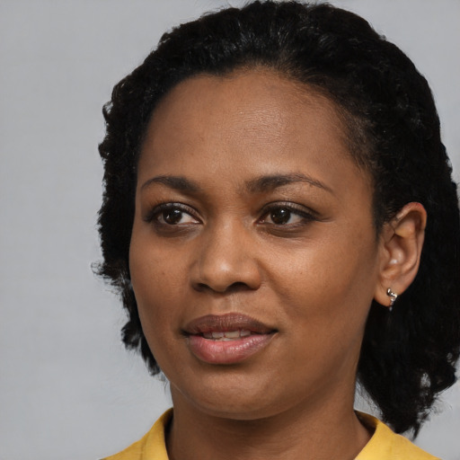 Joyful black young-adult female with short  black hair and brown eyes