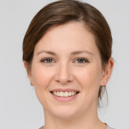 Joyful white young-adult female with medium  brown hair and grey eyes