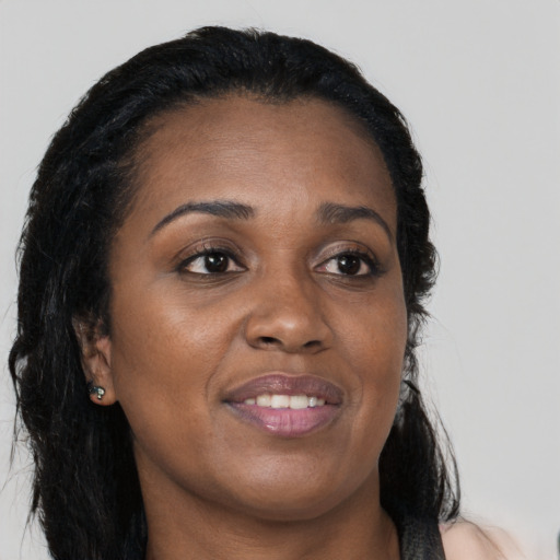 Joyful black young-adult female with long  brown hair and brown eyes
