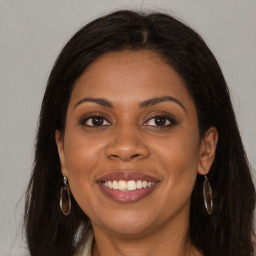 Joyful black young-adult female with long  brown hair and brown eyes