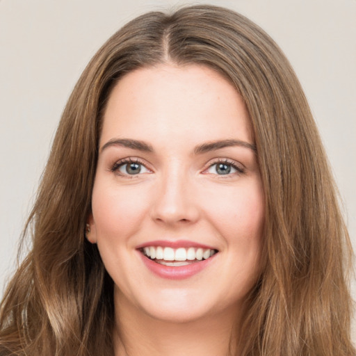 Joyful white young-adult female with long  brown hair and green eyes