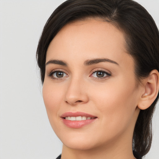 Joyful white young-adult female with long  brown hair and brown eyes