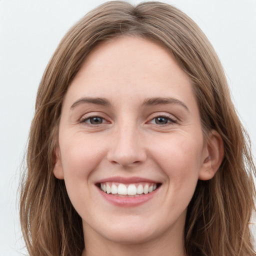 Joyful white young-adult female with long  brown hair and grey eyes