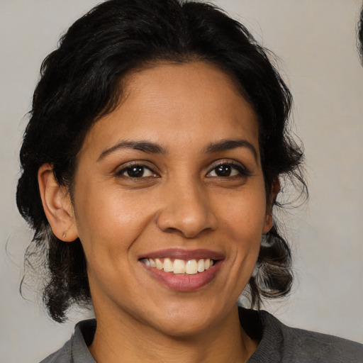 Joyful latino young-adult female with medium  black hair and brown eyes