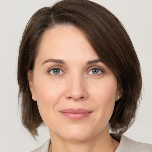 Joyful white adult female with medium  brown hair and grey eyes