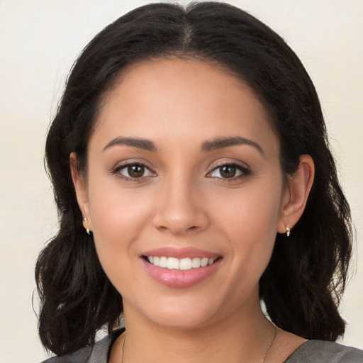 Joyful latino young-adult female with long  brown hair and brown eyes