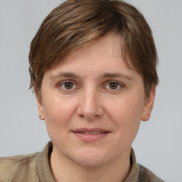 Joyful white young-adult female with short  brown hair and grey eyes