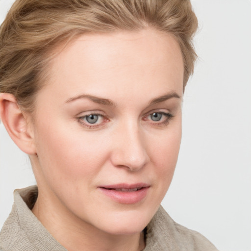 Joyful white young-adult female with short  brown hair and blue eyes