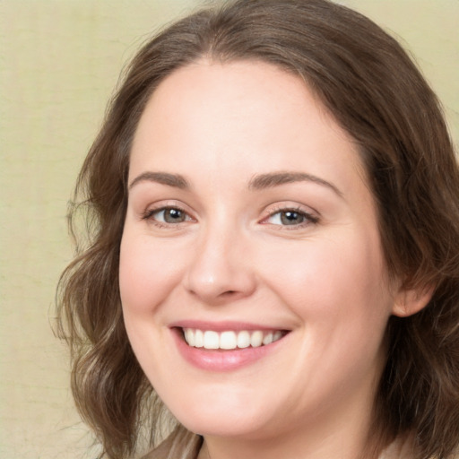 Joyful white young-adult female with medium  brown hair and green eyes