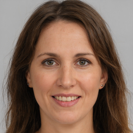 Joyful white adult female with long  brown hair and brown eyes