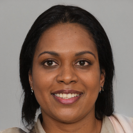 Joyful black young-adult female with long  brown hair and brown eyes