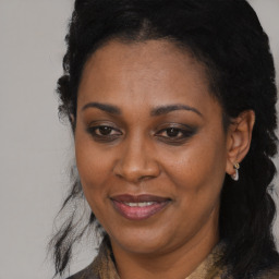 Joyful black adult female with long  brown hair and brown eyes