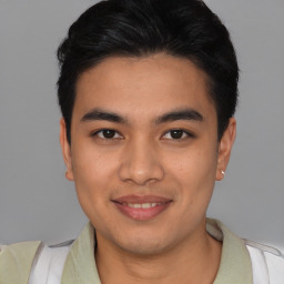 Joyful latino young-adult male with short  brown hair and brown eyes