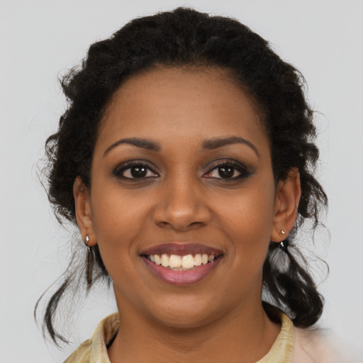 Joyful black young-adult female with long  brown hair and brown eyes